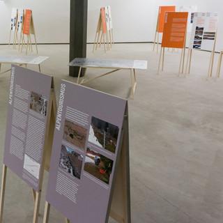 Die Wanderausstellung - Beispielhafte Anordnung der Ausstellungselemente (Ländertexte in orange, Hauptkapitel (Wasserkraft, Tourismus und Klimawandel) in grau, Projekttafeln in weiß)
&nbsp;