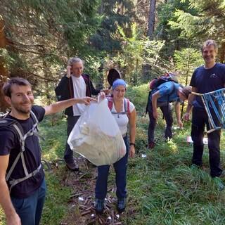 Gruppe Jugendlicher sammelt Müll in der Natur. Die Plastiktüte ist voll.  Foto: Jubi/ Sabine Fröhlich
