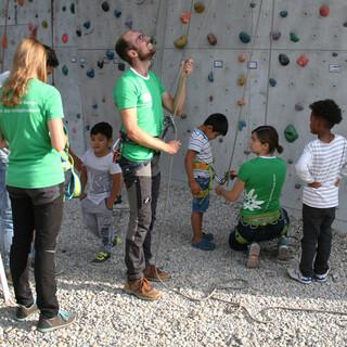Viele Ehrenamtlichen helfen den Kleinen an der Kletterwand. Foto: DAV Rottenburg