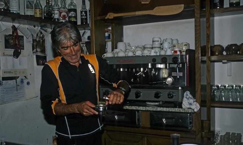 Rifugio Lissone - 6. Etappe: Domenico Ferri, der Hüttenwirt des Rifugio Lissone, bereitet einen wärmenden Cappuccino zu. Der Bergführer schafft eine angenehme, gemütliche Atmosphäre in dem großen Zweckbau.