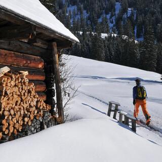 Mit den Skiern geht es an der Schneckenalm vorbei Richtung Gsuchmauer. Foto: Stefan Herbke