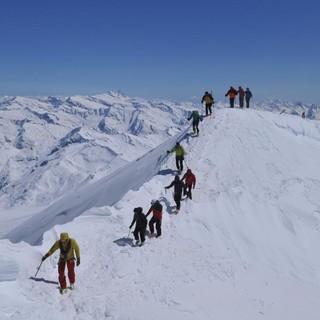 Skirunde Großvenediger: Der etwas luftige Gratübergang zum Gipfelkreuz des Großvenedigers, links der Bildmitte der Großglockner. Foto: Stefan Herbke