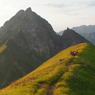 Eine Jugendgruppe genießt den tiefen Sonnenstand am Berg. Foto: Stefan Spieker