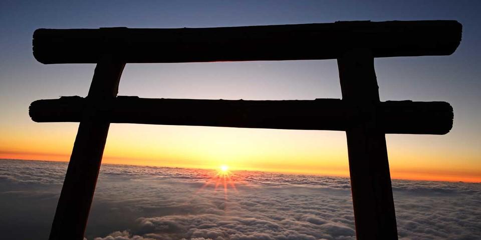 Am heiligen Berg Fuji steigt die Sonne unter einem Torii-Bogen aus den Wolken. Foto: Norbert Eisele-Hein