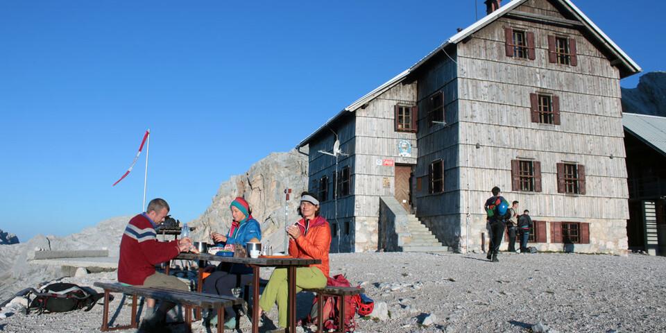Brotzeit vor der Dom Planika, der großen Hütte am Fuße des Triglav Gipfelaufbaus. Foto: Michael Pröttel