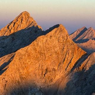 Wer eine Stirnlampe für den Abstieg hat, kann die Abendstimmung auf den Gipfeln genießen. Foto: Heinz Zak